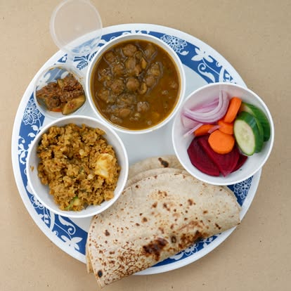 An authentic North Indian thali with butter chicken, dal makhani, paneer, rice, roti and gulab jamun